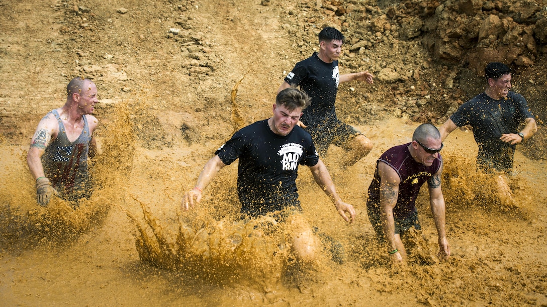 Marines run down a muddy slope during the annual Mud Run at Camp Hansen in Okinawa, Japan, April 9, 2017. Troops, their families and other members of the community participated in the event. Marine Corps photo by Lance Cpl. Andy Martinez