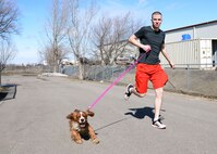Airman 1st Class Jeremiah Davidson, 5th Logistics Readiness Squadron vehicle maintainer, runs with a dog at the Souris Valley Animal Shelter in Minot, N.D., March 29, 2017.  Airmen volunteered two hours to help clean, organize and take care of the animals at the shelter. (U.S. Air Force photo/Airman 1st Class Dillon J. Audit) 