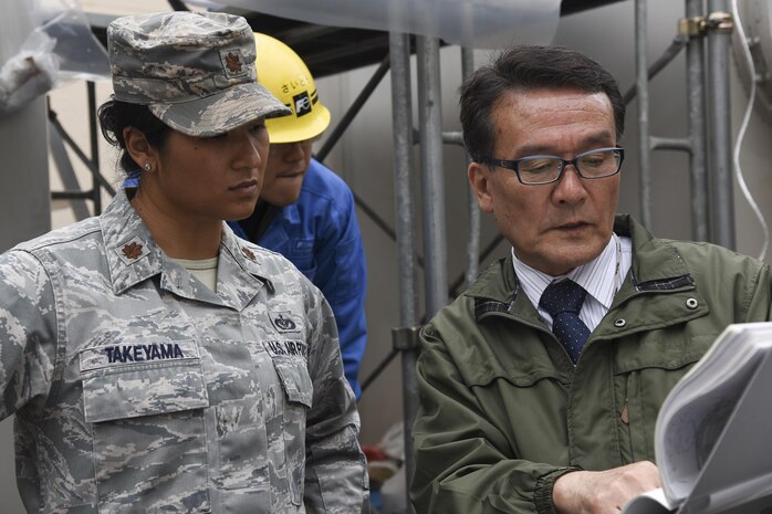 A contractor member from Sanwa Engineering Company, Limited explains the progress of the project to Major Korinne Takeyama, 374th Civil Engineer Squadron operations flight commander, at Yokota Air Base, Japan, April 8, 2017. The 374th Civil Engineer Squadron along with contractors repaired the gas leak from one of the gas-insulated high-voltage switchgear in the West Substation to prevent further damage.