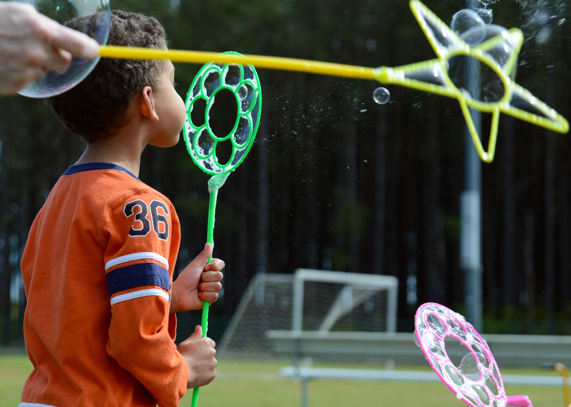 A Team Shaw child blows bubbles during a Month of the Military Child celebration at Shaw Air Force Base, S.C., April 8, 2017. Approximately 2,000 Team Shaw members participated in events, whuch included an egg hunt, magic show and train ride. (U.S. Air Force photo by Airman 1st Class Kathryn R.C. Reaves)