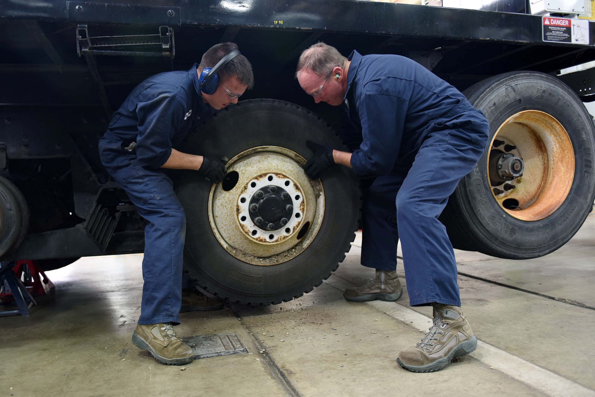 Col. Gregory Wood, 30th Space Wing vice commander, assists Senior Airman Christopher Champagne, 30th Logistics Readiness Squadron vehicle maintainer, remove the wheels of an Altec crane, April 7, 2017, at Vandenberg Air Force Base, Calif. Wood visited the 30th LRS to interact with Airmen and experience the mission.  (U.S. Air Force photo by Tech. Sgt. Jim Araos/Released)