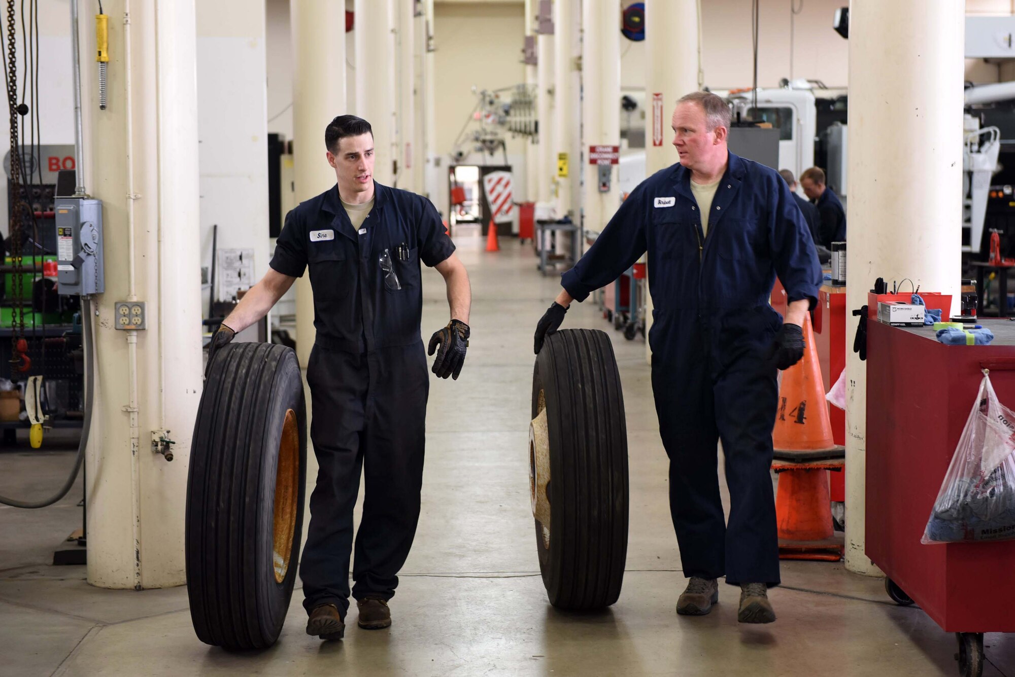 Col. Gregory Wood, 30th Space Wing vice commander, assists Senior Airman Nathan Sine, 30th Logistics Readiness Squadron vehicle maintainer, transport the wheels of an Altec crane, April 7, 2017, at Vandenberg Air Force Base, Calif. Wood visited the 30th LRS to interact with Airmen and experience the mission.  (U.S. Air Force photo by Tech. Sgt. Jim Araos/Released)