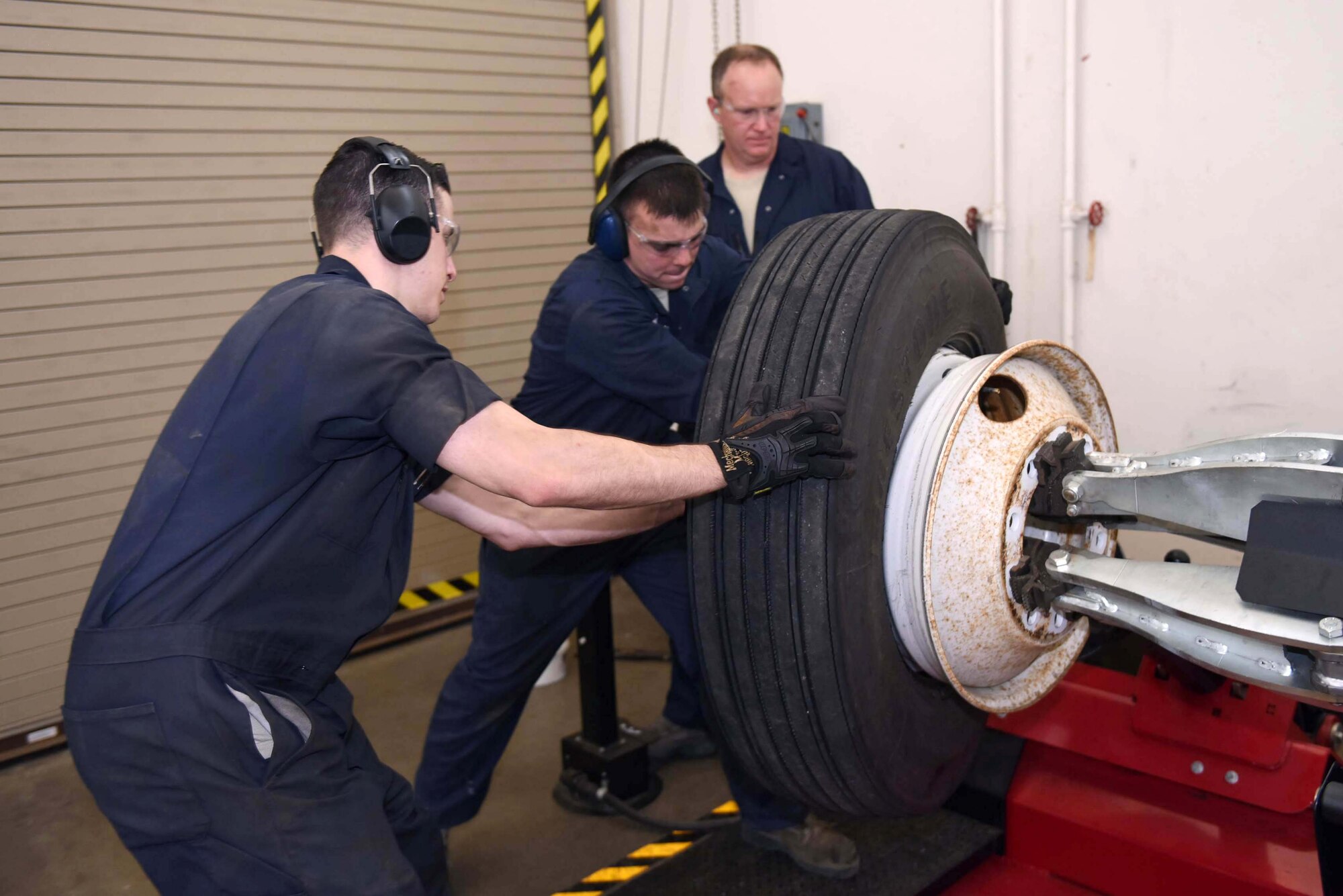 Col. Gregory Wood, 30th Space Wing vice commander, assists Senior Airmen Nathan Sine and Christopher Champagne, 30th Logistics Readiness Squadron vehicle maintainers, change a wheel with a Goats wheel changer, April 7, 2017, at Vandenberg Air Force Base, Calif.  Wood visited the 30th LRS to interact with Airmen and experience the mission.  (U.S. Air Force photo by Tech. Sgt. Jim Araos/Released)