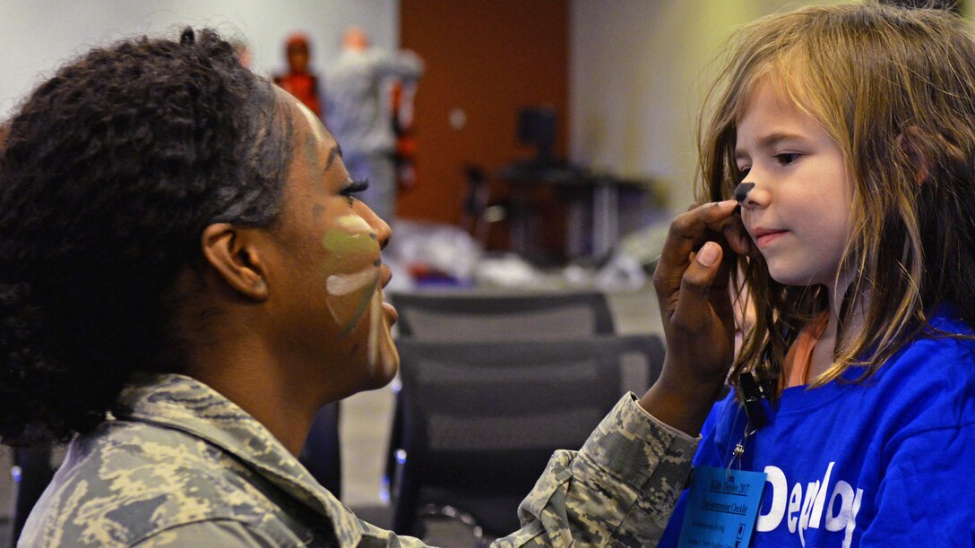 Air Force Airman 1st Class Deja Hunter paints the nose of a child going through the Kids Deployment Line during a Month of the Military Child event at Ellsworth Air Force Base, S.D., April 8, 2017. Air Force photo by Airman Nicolas Z. Erwin