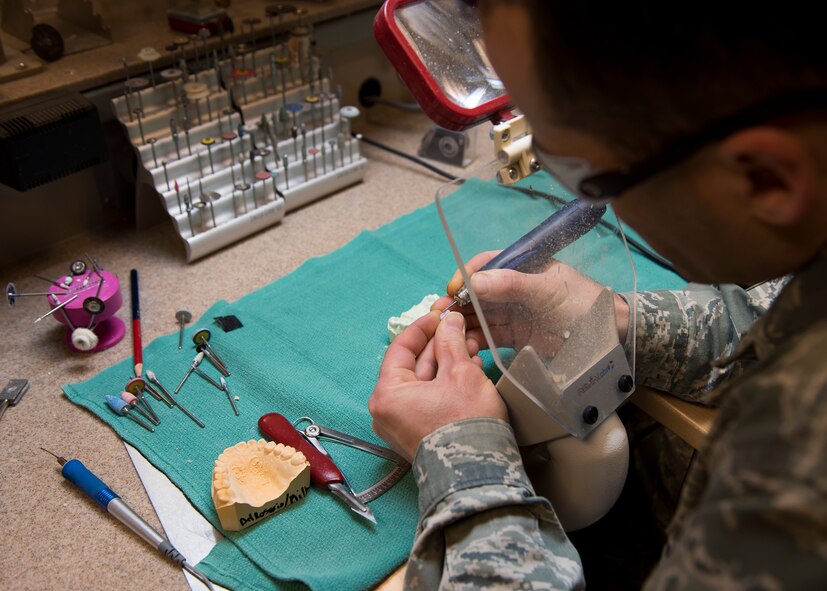 Tech. Sgt. Manuel Painter, 92nd Aerospace Medicine Squadron dental technician, mills down a cast tooth as part of the crown making process April 07, 2017, at Fairchild Air Force Base, Wash. Crown making is an intensive process that requires a series of casting, milling and coating steps. (U.S. Air Force photo/A1C Ryan Lackey)