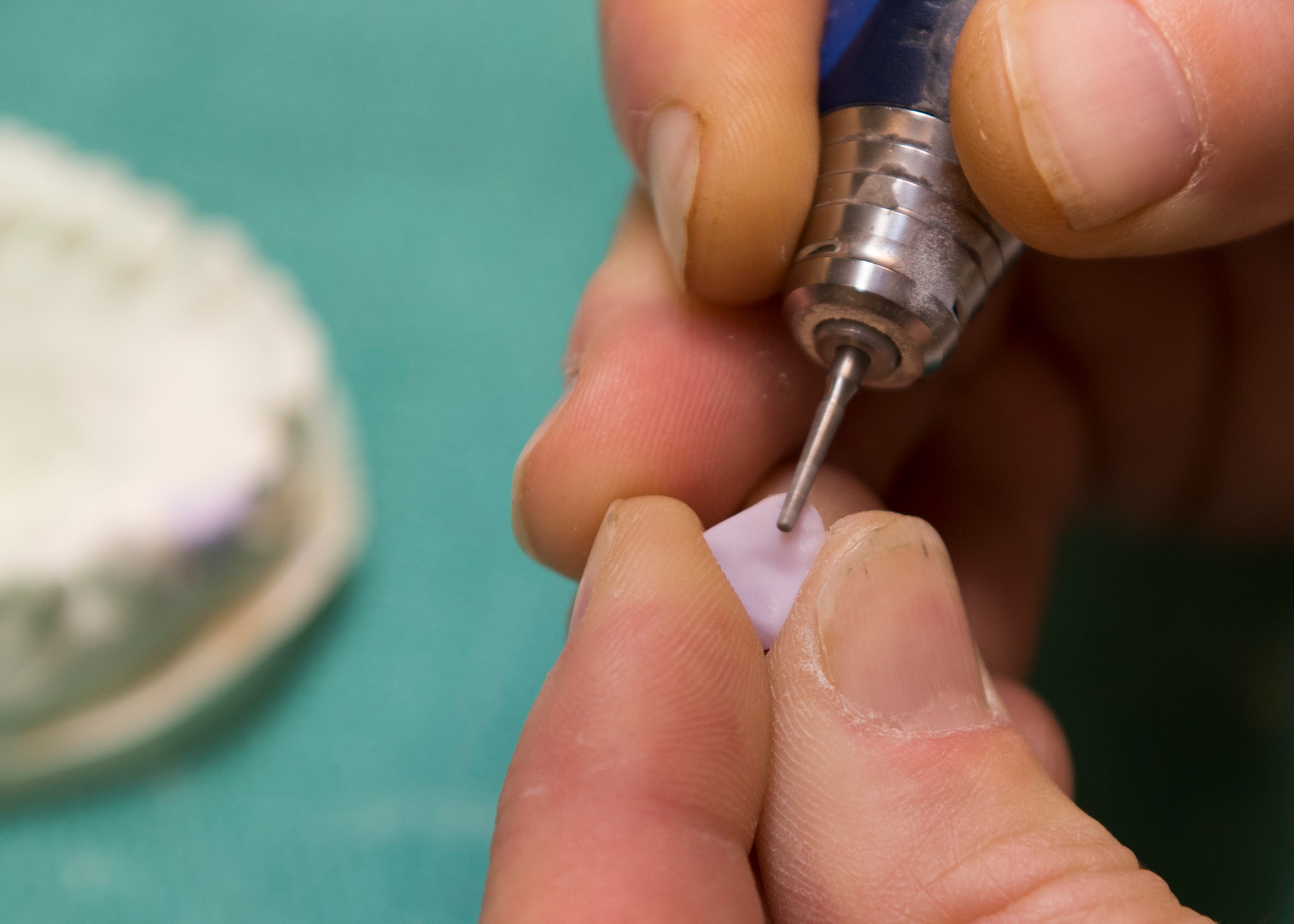 Tech. Sgt. Manuel Painter, 92nd Aerospace Medicine Squadron dental technician, delicately details a cast tooth for a dental prosthesis April 07, 2017, at Fairchild Air Force Base, Wash. Artistic and machining ability is a great asset for dental lab technicians, as the work requires an appreciation for form and detail. (U.S. Air Force photo/A1C Ryan Lackey)