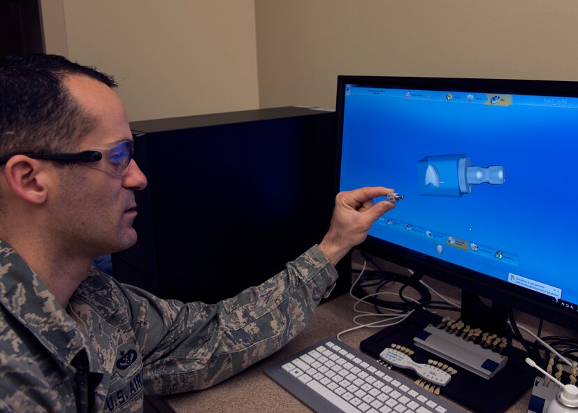 Tech. Sgt. Manuel Painter, 92nd Aerospace Medicine Squadron dental technician, displays a milling block and its computer simulated 3-D model prior to milling April 07, 2017, at Fairchild Air Force Base, Wash. New advances in dental machining has enabled technicians to recreate teeth with greater speed and precision. (U.S. Air Force photo/A1C Ryan Lackey)