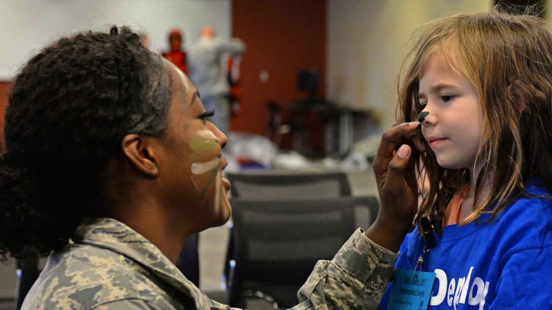 Air Force Airman 1st Class Deja Hunter paints the nose of a child going through the Kids Deployment Line during a Month of the Military Child event at Ellsworth Air Force Base, S.D., April 8, 2017. Air Force photo by Airman Nicolas Z. Erwin