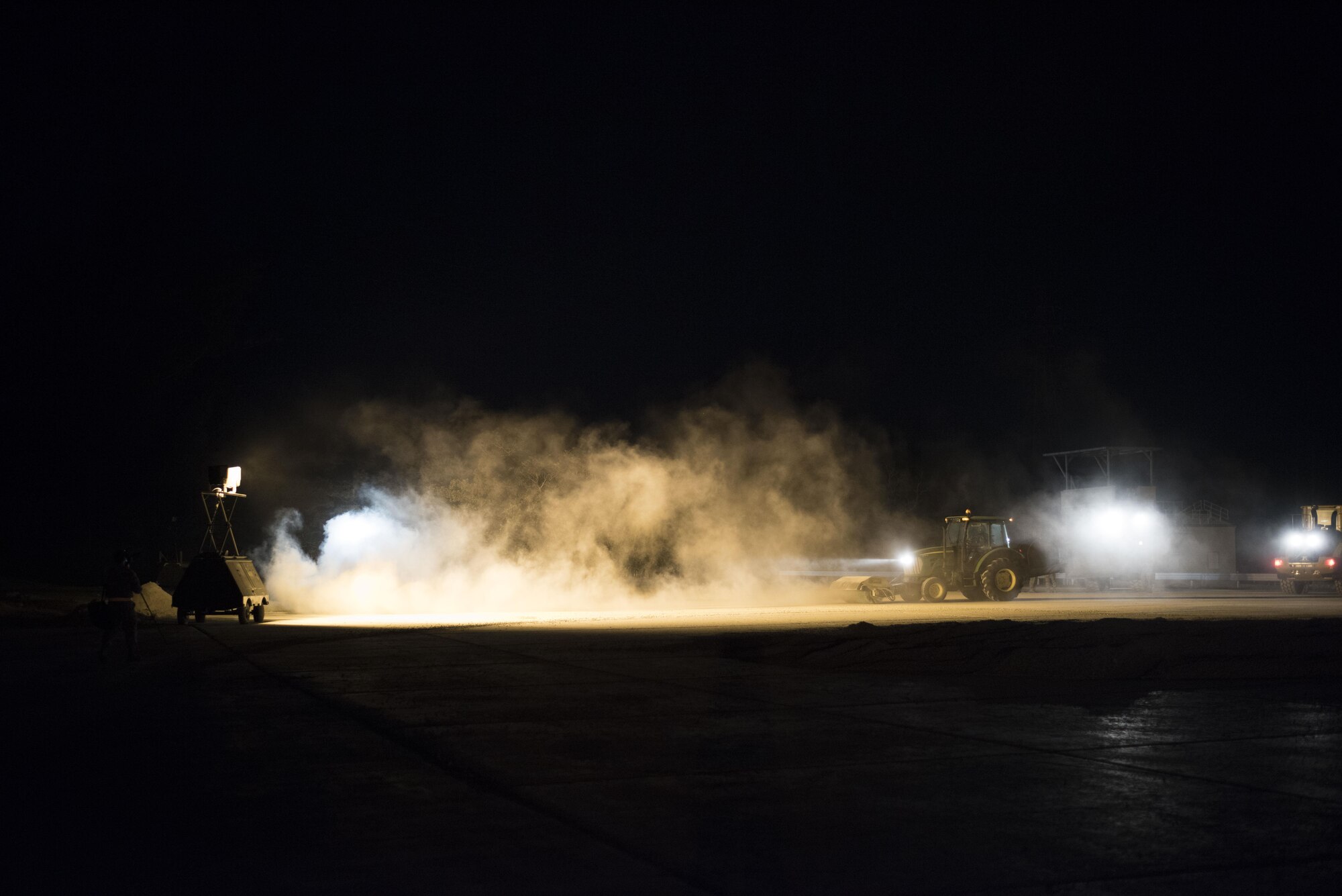 U.S. Air Force civil engineer Airmen use specialized equipment to clear debris from a runway during a no-notice exercise April 12, 2017, at Kadena Air Base, Japan. During the airfield damage repair portion of the exercise, the 18th CES trains throughout the night to ensure mission capability in all conditions. (U.S. Air Force photo by Senior Airman Omari Bernard/Released)