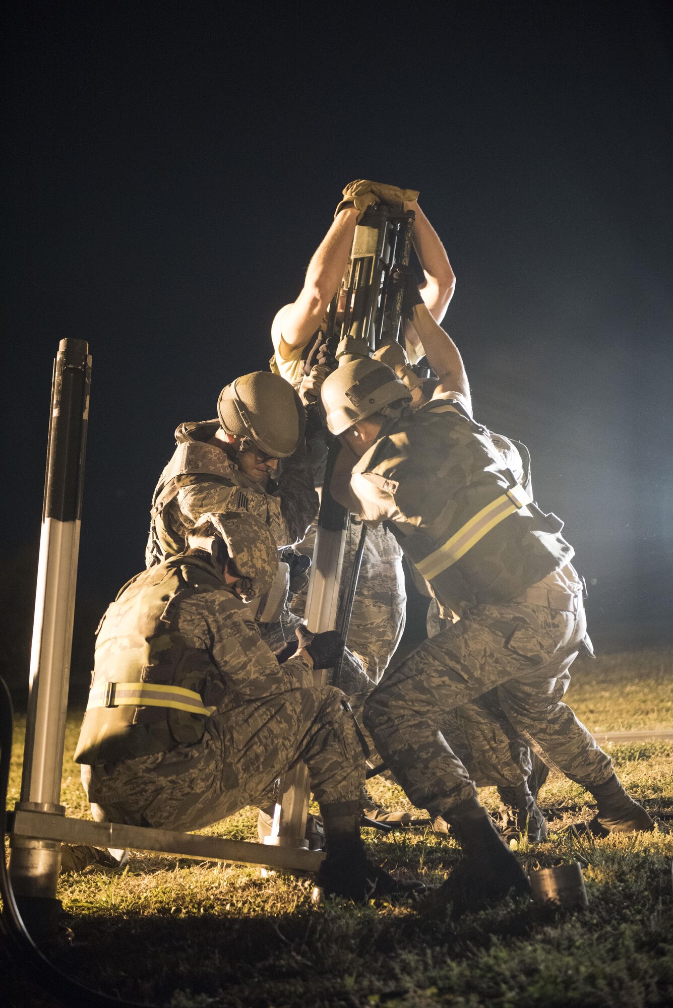 U.S. Air Force civil engineer Airmen from the 18th Civil Engineer Squadron hammer in stakes to secure a mobile aircraft arresting system during a no-notice exercise April 12, 2017, at Kadena Air Base, Japan. The MAAS is used to capture hook-prepared fighter aircraft to ensure safe landings. (U.S. Air Force photo by Senior Airman Omari Bernard/Released)