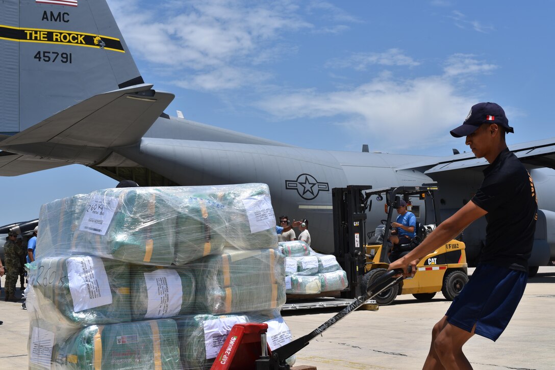 Cargo provided by the U.S. Agency for International Development is unloaded and transported by local Peruvian workers April 6, 2017, in Lima, Peru. Two C-130Js from Little Rock Air Force Base, Ark., were launched at the request of the Government of Peru to assist humanitarian disaster operations. (U.S. Air Force photo by Staff Sgt. Jael Laborn)