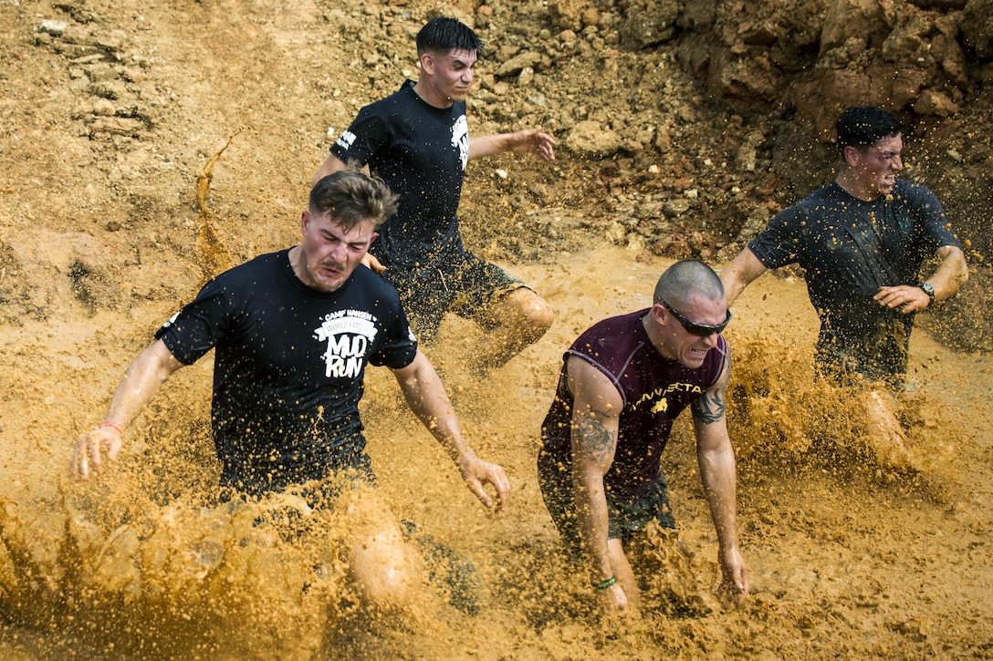 Marines run down a muddy slope during the annual Mud Run at Camp Hansen in Okinawa, Japan, April 9, 2017. Service members, their families, area residents and others participated in the event. Marine Corps photo by Lance Cpl. Andy Martinez