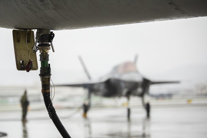 A hose attached to a KC-130J Hercules with Marine Aerial Refueler Transport Squadron (VMGR) 152 pumps fuel into an F-35B Lightning II aircraft with Marine Fighter Attack Squadron (VMFA) 121 during aviation delivered ground refueling training at Marine Corps Air Station Iwakuni, Japan, April 11, 2017. The ADGR marked the first evolution of this form of refueling for VMFA-121’s F-35B Lightning II aircraft, and it increases the squadron’s ability to refuel by C-130 aircraft in austere locations when other resources may not be available.  (U.S. Marine Corps photo by Lance Cpl. Joseph Abrego)