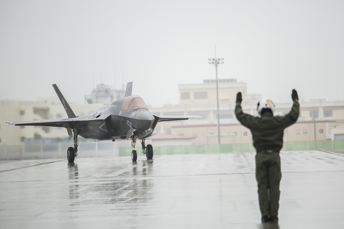 U.S. Marine Corps Sgt. Koen Haaksma, a KC-130J Hercules crew master with Marine Aerial Refueler Transport Squadron (VMGR) 152, directs an F-35B Lightning II aircraft with Marine Fighter Attack Squadron (VMFA) 121 off the flight line after refueling during aviation delivered ground refueling training at Marine Corps Air Station Iwakuni, Japan, April 11, 2017. The ADGR marked the first evolution of this form of refueling for VMFA-121’s F-35B Lightning II aircraft, and it increases the squadron’s ability to refuel by C-130 aircraft in austere locations when other resources may not be available.  (U.S. Marine Corps photo by Lance Cpl. Joseph Abrego)