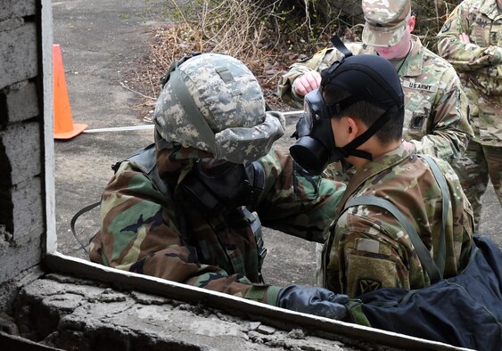 U.S. Army Pfc. Sung Hoon Lee, 2nd Battalion, 1st Air Defense Artillery medic, simulates decontaminating a Soldier during the 35th Air Defense Artillery Brigade Expert Field Medical Badge preliminary competition at Osan Air Base, Republic of Korea, April 6, 2017. During the competition, participants had to overcome two combat trauma lanes, testing the medic’s abilities, determination and strength through scenarios such as medical management, care under fire, tactical movement, decontamination and litter movement. (U.S. Air Force photo by Staff Sgt. Alex Fox Echols III)