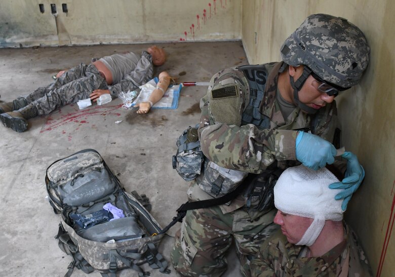 U.S. Army Spc. Sung Seo, 6th Battalion, 52nd Air Defense Artillery medical NCO in charge, treats a simulated head wound of U.S. Air Force Senior Airman Jackson Sullivan, 51st Security Forces Squadron response force leader, during the 35th Air Defense Artillery Brigade Expert Field Medical Badge preliminary competition at Osan Air Base, Republic of Korea, April 6, 2017. During the competition, Seo earned the top performer slot over the other 14 participants. (U.S. Air Force photo by Staff Sgt. Alex Fox Echols III)
