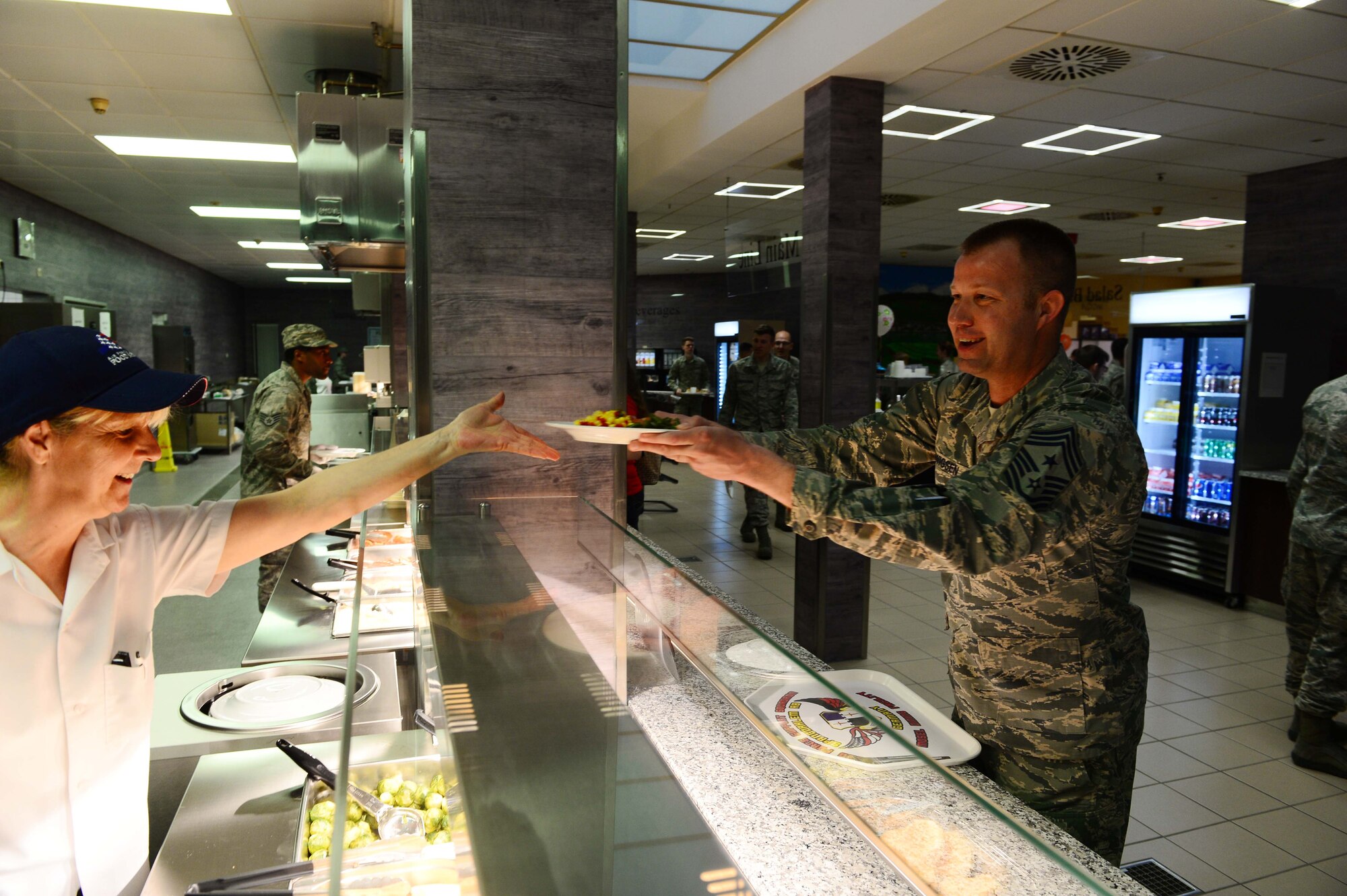 Chief Master Sgt. Edwin Ludwigsen, 52nd Fighter Wing command chief, grabs his first lunch at the updated Dining Facility at Spangdahlem Air Base after several months of renovations that made meal service unavailable to the Saber community, April 10, 2017. Upgrades to the DFAC include new kitchen equipment like ovens and a walk in fridge, air conditioning installed in the kitchen, a new service line, repainting the walls and adding murals in the dining rooms to reflect the base's connection to the local community. (U.S. Air Force photo by Senior Airman Joshua R. M. Dewberry)