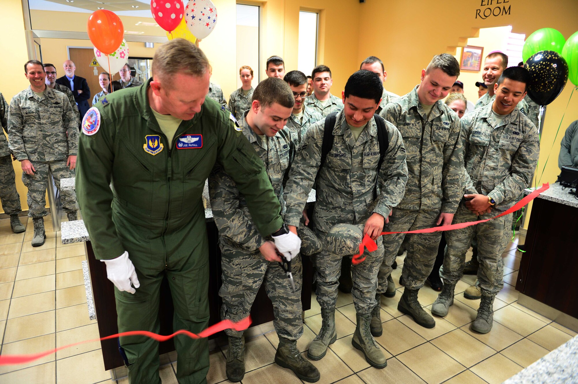 Col. Joseph McFall, 52nd Fighter Wing commander, and Spangdahlem Airmen cut the ceremonial ribbon at the updated Dining Facility at Spangdahlem Air Base after several months of renovations that made meal service unavailable to the Saber community, April 10, 2017. Upgrades to the DFAC include new kitchen equipment like ovens and a walk in fridge, air conditioning installed in the kitchen, a new service line, repainting the walls and adding murals in the dining rooms to reflect the base's connection to the local community. (U.S. Air Force photo by Senior Airman Joshua R. M. Dewberry)