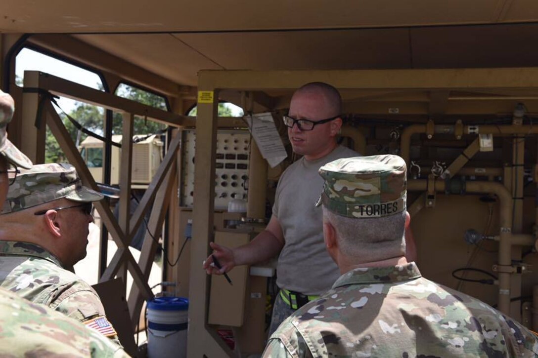 Spc. Pedro López, water purification specialist assigned to the 973rd Quartermaster Company, briefs Brig. Gen. Alberto C Rosende, commanding general for the 1st Mission Support Command, Brig. Gen. Richard Torres, deputy commander U.S. Army South, and other senior leaders on the water purification process during Beyond the Horizon: 2017-Belize exercise April 6.