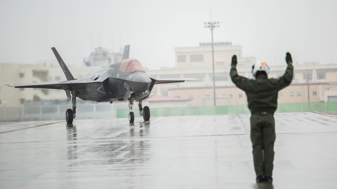 U.S. Marine Corps Sgt. Koen Haaksma, a KC-130J Hercules crew master with Marine Aerial Refueler Transport Squadron (VMGR) 152, directs an F-35B Lightning II aircraft with Marine Fighter Attack Squadron 121 off the flight line after refueling during aviation delivered ground refueling training at Marine Corps Air Station Iwakuni, Japan, April 11, 2017. The ADGR marked the first evolution of this form of refueling for VMFA-121’s F-35B Lightning II aircraft, and it increases the squadron’s ability to refuel by C-130 aircraft in austere locations when other resources may not be available.  