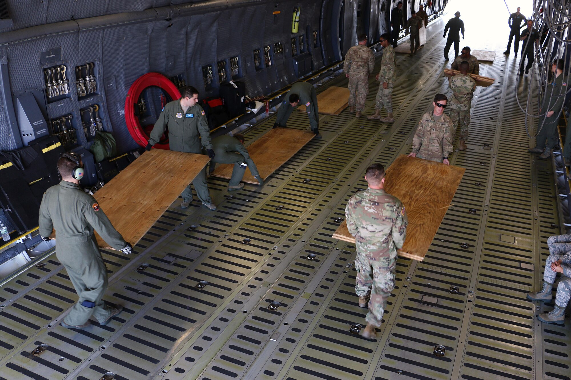 Soldiers and airmen unload plywood to lay down for air load training March 28, 2017 at Hunter Army Airfield, Ga. The plywood is a barrier between the C5 "Super Galaxy" aircraft and the Abrams tanks and Bradley fighting vehicles of 2nd Battalion, 7th Infantry Regiment, 1st Armored Brigade Combat Team, 3rd Infantry Division. Soldiers of 2-7th Inf. make up the Immediate Ready Company, which maintains readiness to support the Global Response Force within 18 hours of notification. (U.S. Army photo by Staff Sgt. Candace Mundt/Released)