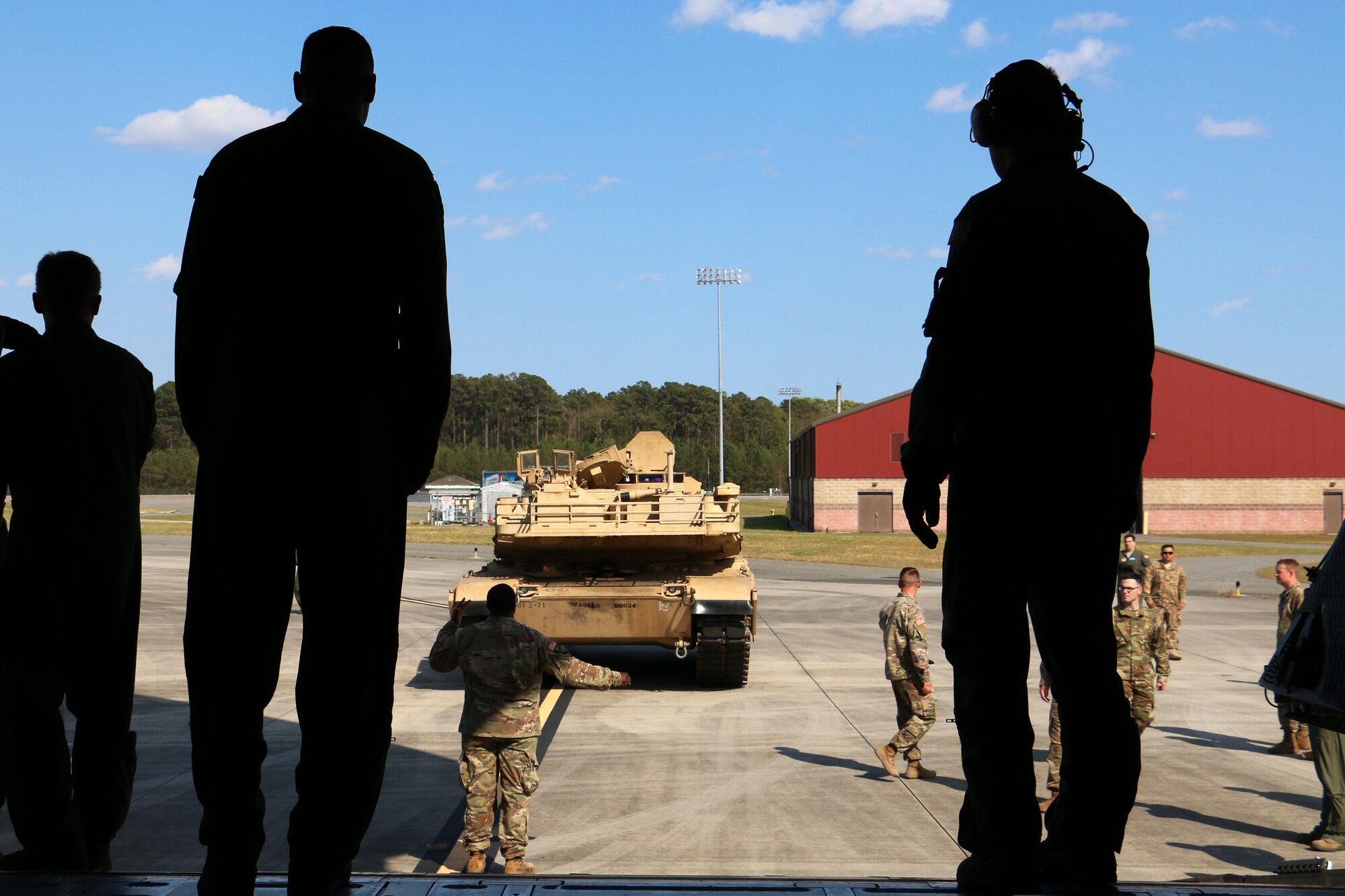 Airmen watch as Soldiers from 2nd Battalion, 7th Infantry Regiment, 1st Armored Brigade Combat Team, 3rd Infantry Division prepare to load an M1A1 Abrams tank onto a C5 "Super Galaxy" aircraft March 28, 2017 at Hunter Army Airfield, Ga. Airmen of 9th Airlift Squadron, 436th Airlift Wing out of Dover Air Force Base, Del., coordinated air support with to support 2-7th Inf. air load training for their Immediate Ready Company. The IRC maintains readiness to support the Global Response Force within 18 hours of notification. (U.S. Army photo by Staff Sgt. Candace Mundt/Released)