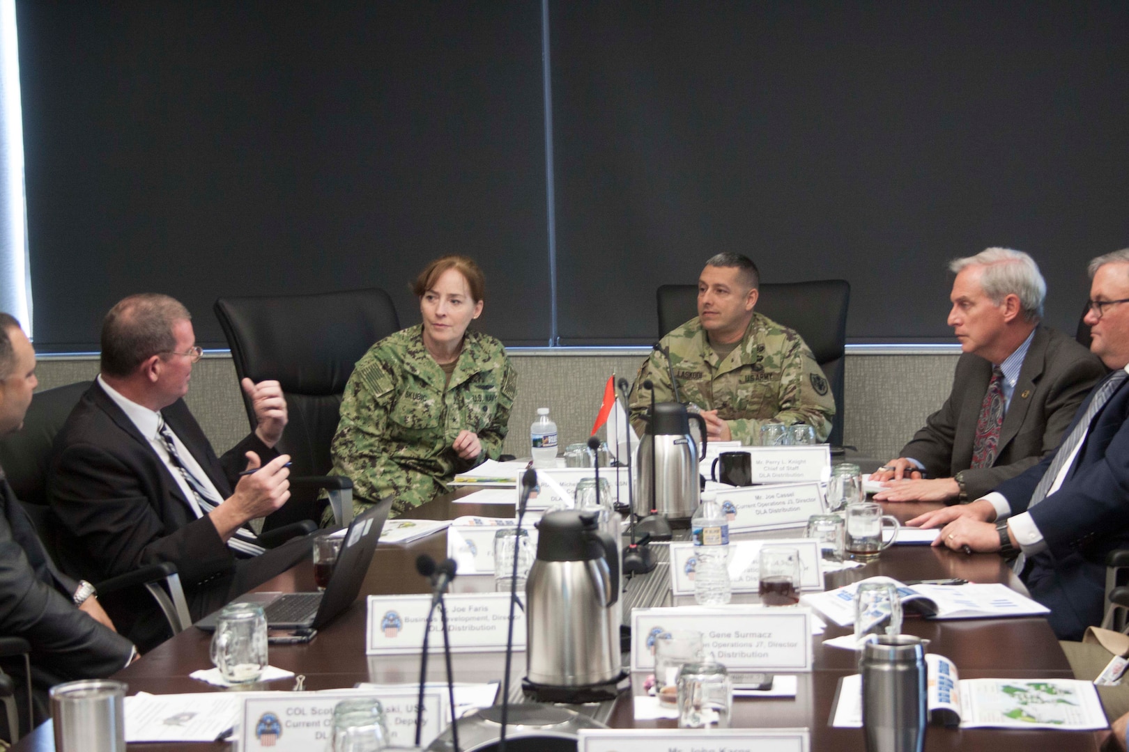 Scott Rosbaugh, DLA Distribution Future Plans director, left, outlines DLA Distribution’s Campaign Plan to DLA Land and Maritime commander Navy Rear Adm. Michelle Skubic, second from left, during a roundtable discussion with DLA Distribution commander Army Brig. Gen. John Laskodi.  