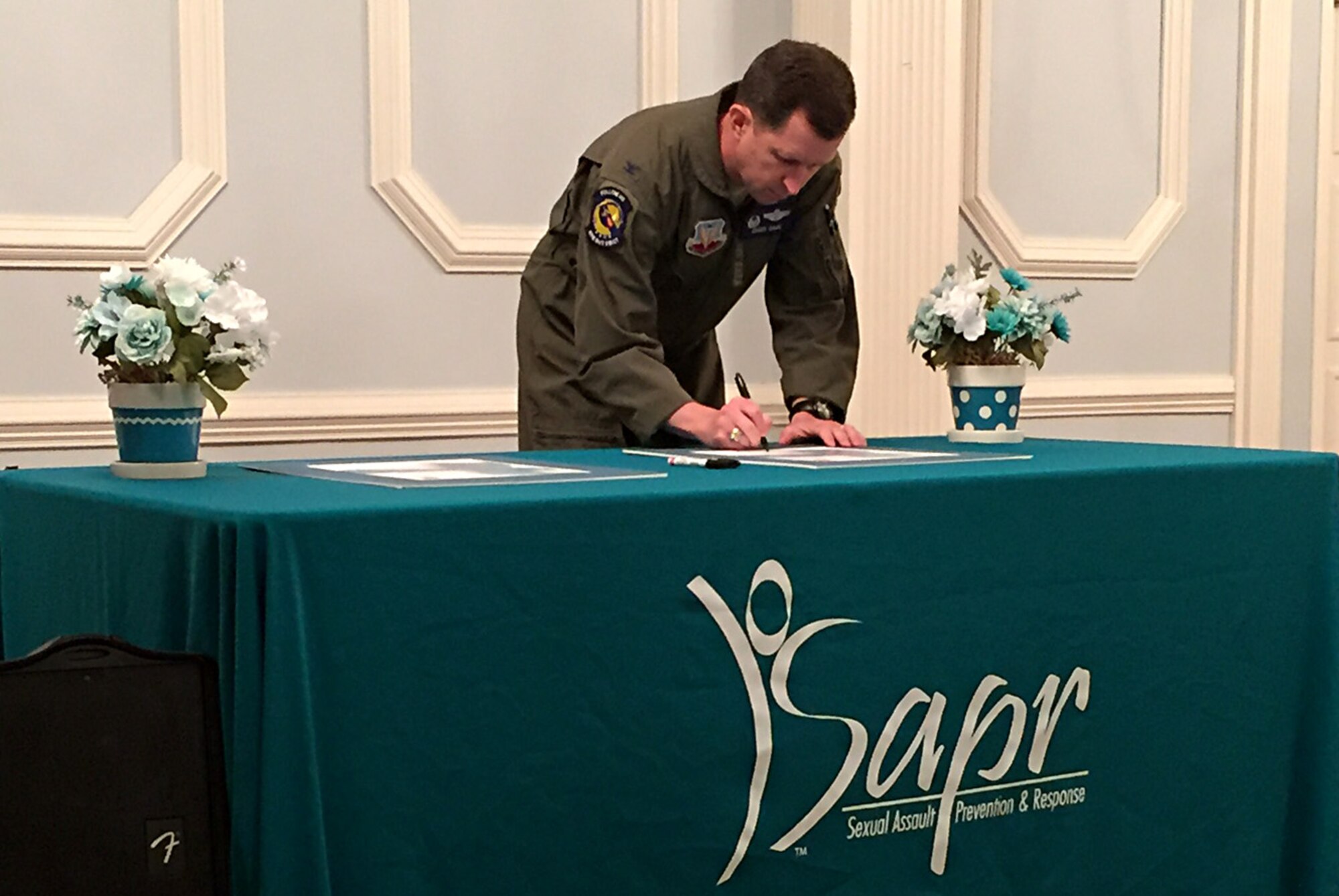 Col. Christopher Sage, 4th Fighter Wing commander, signs a Sexual Assault Prevention and Response Proclamation during a SAPR seminar, April 3, 2017, at Seymour Johnson Air Force Base, North Carolina. The 2017 Sexual Assault Awareness and Prevention Month theme is, "Protecting Our People Protects Our Mission." (Courtesy photo)