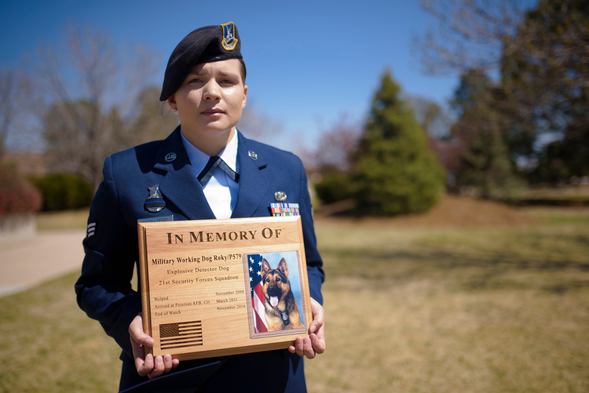 PETERSON AIR FORCE BASE, Colo. –Senior Airman Karissa Fitzpatrick, 21st Security Forces Squadron Military Working Dog handler, holds the plaque commemorating Roky’s, her MWD, career as an integral member of the armed services in the base auditorium at Peterson Air Force Base, Colo., April 10, 2017. Roky was trained to be able to detect explosive substances used to threaten, damage or destroy personnel and property. (U.S. Air Force photo by Airman 1st Class Dennis Hoffman)
