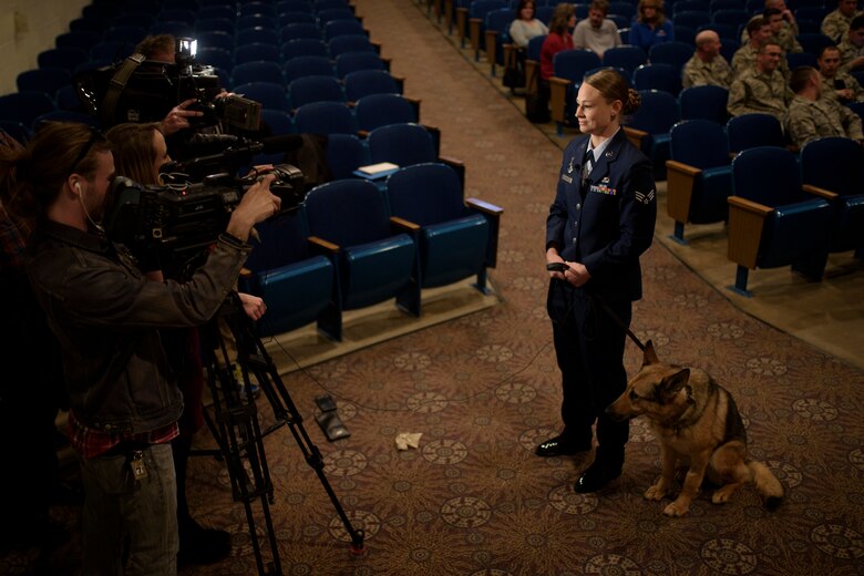 PETERSON AIR FORCE BASE, Colo. –Senior Airman Amanda Legault, 21st Security Forces Squadron Military Working Dog handler, and Gina, 21st SFS MWD, answer questions from the media before Gina’s retirement ceremony in the base auditorium at Peterson Air Force Base, Colo., April 10, 2017. Airmen from all over the base came to celebrate Gina’s nine year career. (U.S. Air Force photo by Airman 1st Class Dennis Hoffman)