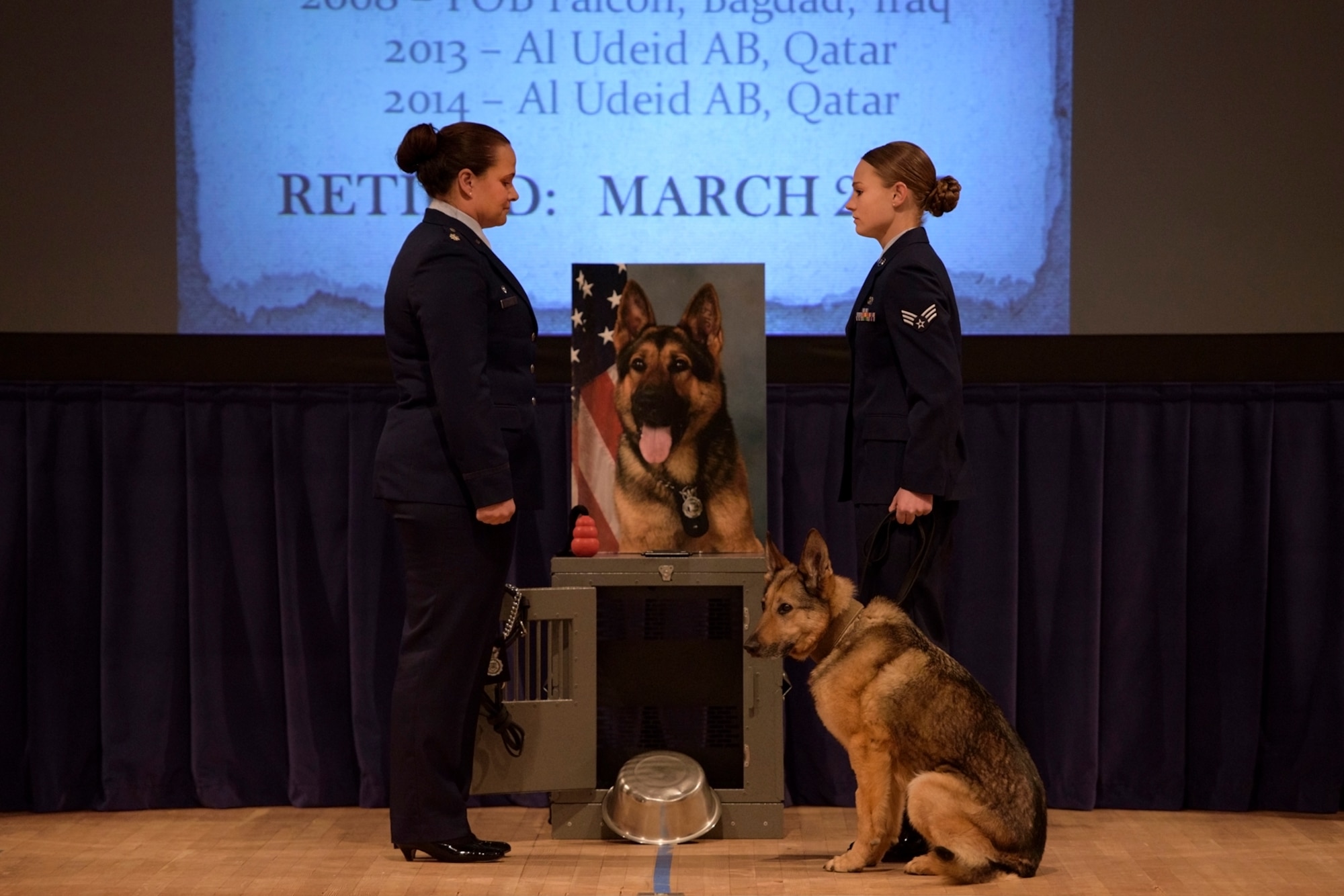 PETERSON AIR FORCE BASE, Colo. –Lt. Col. Nicole Roberts, 21st Security Forces Squadron commander, Senior Airman Amanda Legault, 21st SFS MWD handler, and Gina, 21st SFS MWD, officially retire Gina from active duty in the base auditorium at Peterson Air Force Base, Colo., April 10, 2017. Airmen from all over the base came to celebrate Gina’s nine year career. (U.S. Air Force photo by Airman 1st Class Dennis Hoffman)
