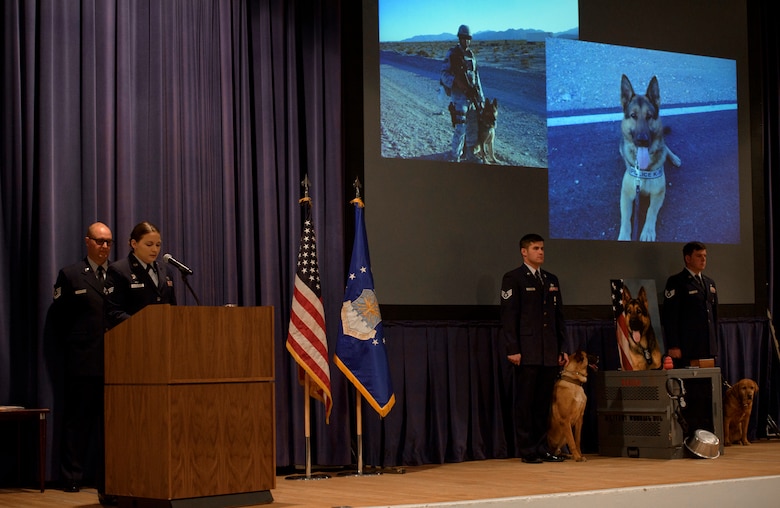 PETERSON AIR FORCE BASE, Colo. –Senior Airman Karissa Fitzpatrick, 21st Security Forces Squadron Military Working Dog handler, speaks to Airmen about her fallen MWD, Roky, during a memorial in the base auditorium at Peterson Air Force Base, Colo., April 10, 2017. In a tribute to Roky’s seven years of service, MWDs and their handlers posted on either side of his kennel for the ceremony. (U.S. Air Force photo by Airman 1st Class Dennis Hoffman)