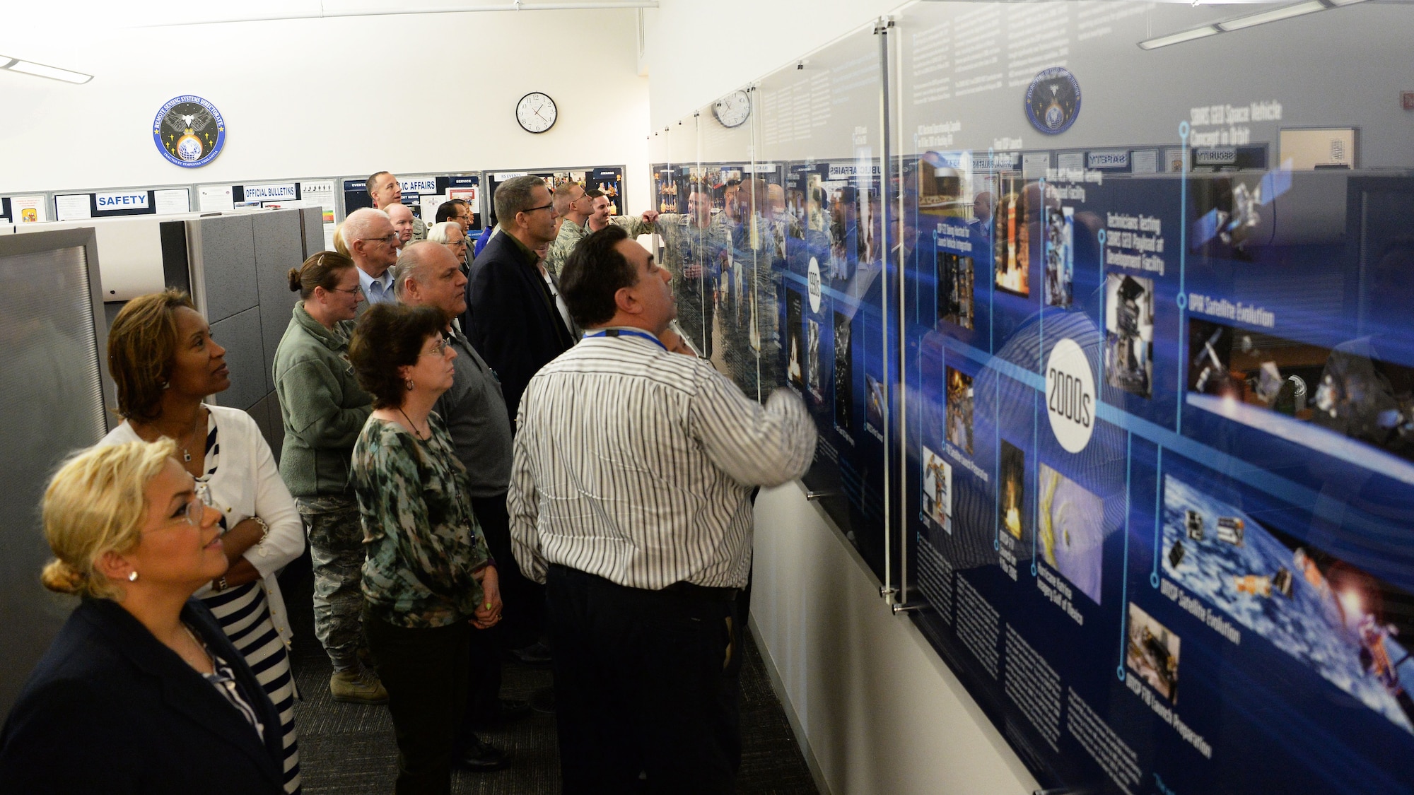 Staff and personnel from the Space and Missile Systems Center’s Remote Sensing Systems Directorate look over the newly unveiled Remote Sensing Heritage Wall at Los Angeles Air Force Base in El Segundo, Calif., March 15, 2017.  The unveiling ceremony commemorates an SMC mission that spans nearly six decades of providing global, persistent, infrared surveillance and environmental monitoring capabilities to our warfighters and the nation. (U.S. Air Force photo / Van De Ha)