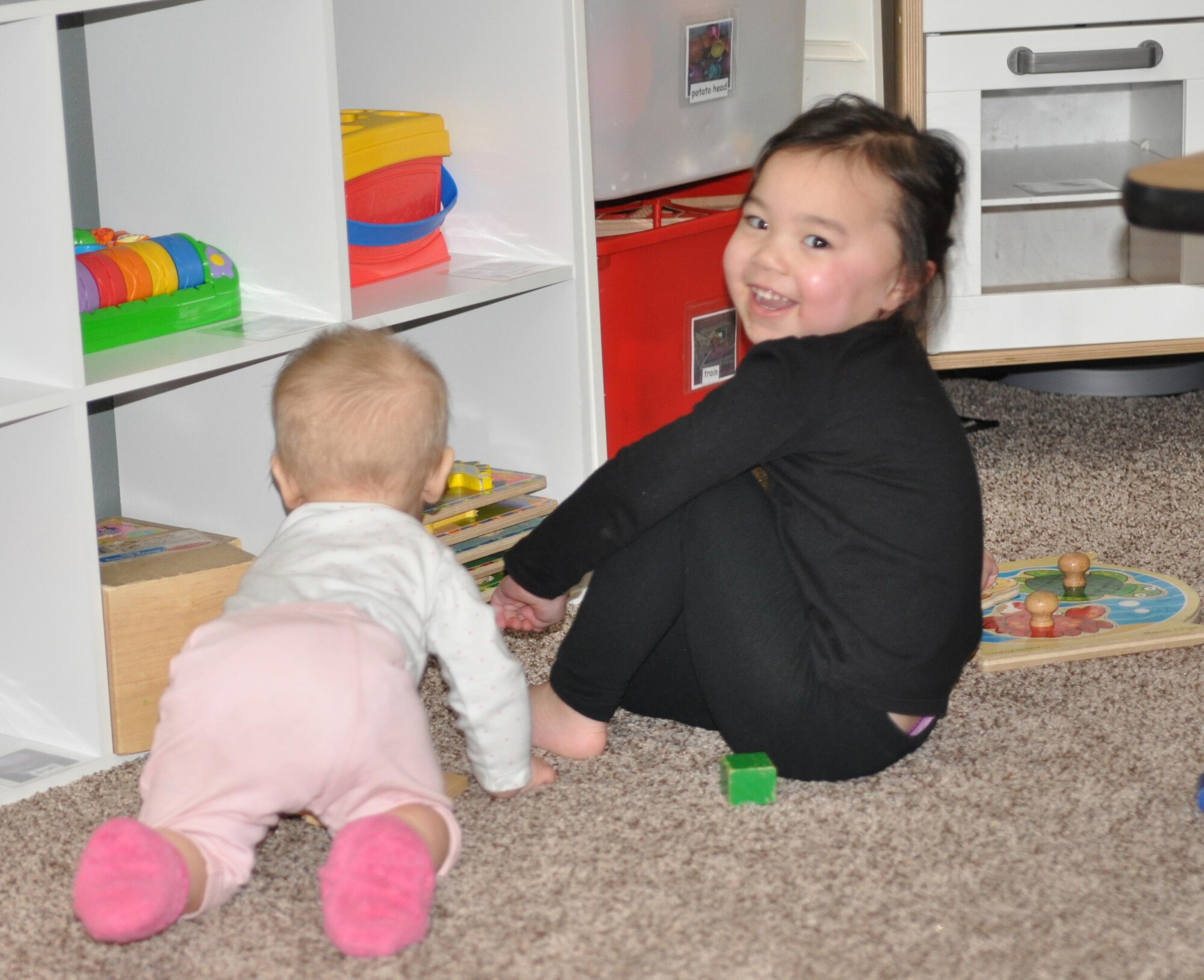 COLORADO SPRINGS, Colo.— Nine-month-old, Sydney, and three-year-old, Jaelyn, both play with toys at the house of Irene Penaflor, a Family Child Care provider, in Colorado Springs, Colo., Feb. 7, 2017. These are two of several military children that Penaflor has provided care for over her 11 years of being with the FCC program. (courtesy photo)