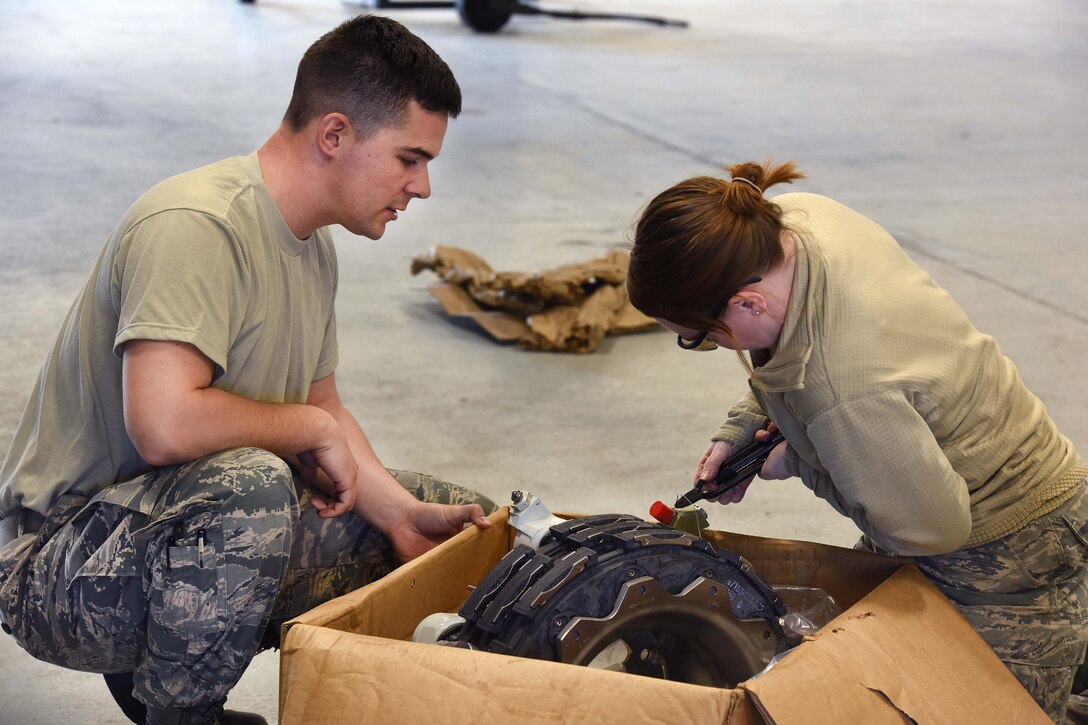 Pennsylvania Air National Guard Staff Sgt. Emery Barrett and Airman 1st Class Reanna Keener move a shuttle valve to the correct side of an aircraft brake assembly for an EC-130J Commando Solo in Middletown, Pa., April 5, 2017. Barrett is a hydraulic technician and Keener is a crew chief assigned to the Pennsylvania Air National Guard’s 193rd Special Operations Maintenance Squadron. Air National Guard photo by Master Sgt. Culeen Shaffer