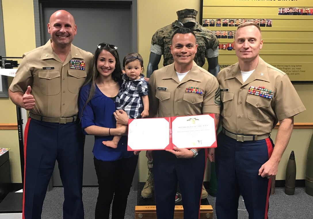 Col. Jason L. Morris  and Maj. Ryan B. Cohen pose for a photo with GySgt Jose A. Arellano and his family after presenting him with a Navy and Marine Corps Achievement Medal at Recruiting Sub-Station Lawton, Okla., April 11. Morris is the commanding officer of 9th Marine Corps District and Cohen is the Commanding Officer of Recruiting Station Oklahoma City. Arellano was presented the award because his sub-station has already met 350 percent of their female recruiting mission for this year. 