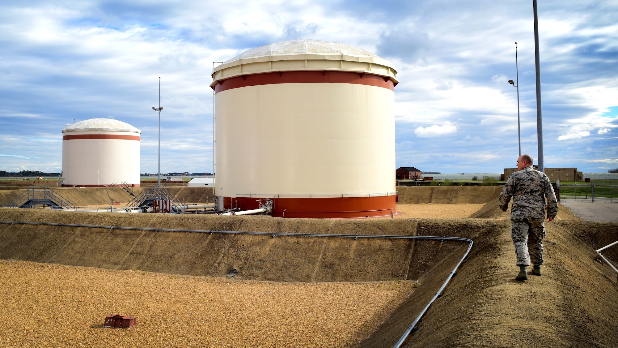 U.S. Air Force Staff Sgt. Benjamin Moore, 733rd Logistics Readiness Squadron fuels facilities supervisor, walks on a dyke in the fuels storage tank farm at Joint Base Langley-Eustis, Va., April 7, 2017. Fuels facilities also receives and stores ground products, such as gasoline, standard low sulfur diesel and biodiesel, which is more environmentally friendly. (U.S. Air Force photo/Staff Sgt. Areca T. Bell)