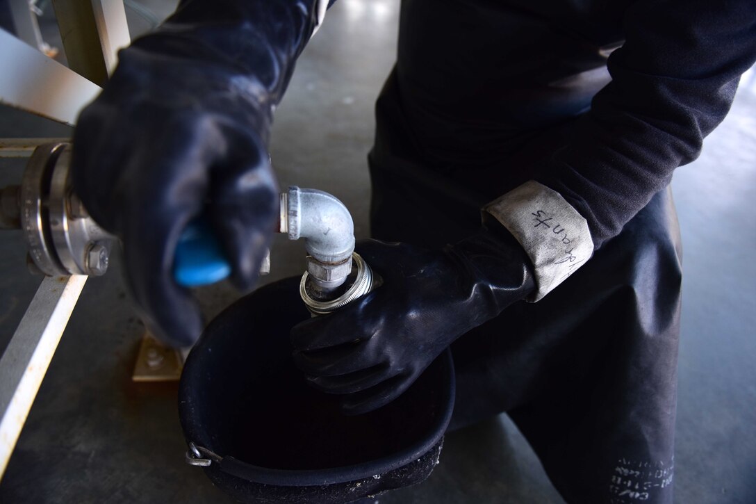 Darryl Hodge, 733rd Logistics Readiness Squadron fuels facilities fuels distribution systems operator, takes a fuel sample at Joint Base Langley-Eustis, Va., April 10, 2017. Fuel facilities Airmen sample jet fuel to make sure it is clear and without contaminants before being used for fueling operations. (U.S. Air Force photo/Staff Sgt. Areca T. Bell)