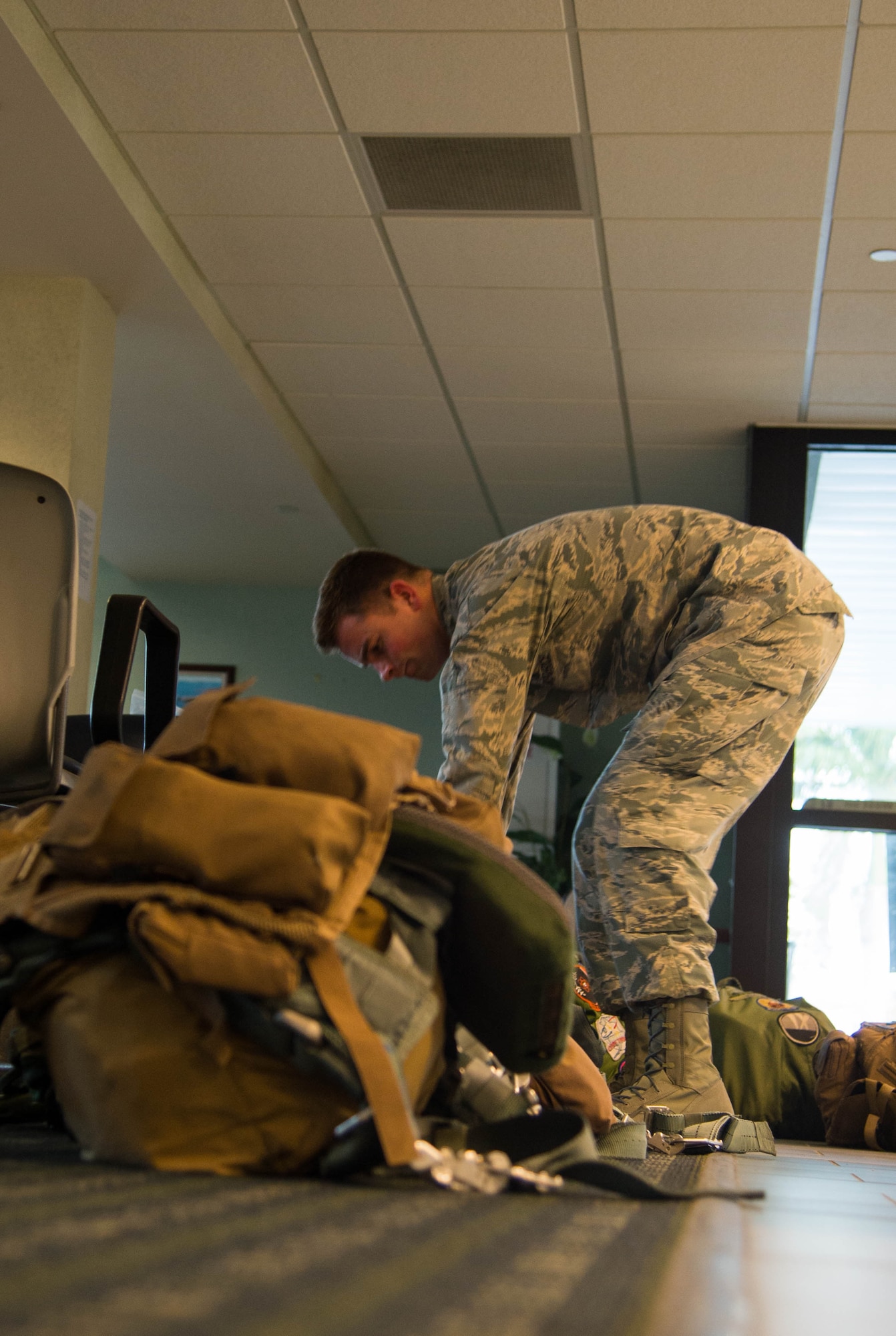 Senior Airman Conner Odom, 7th Operational Support Squadron flight aircrew equipment specialist, inspects B-1 Lancer aircrew survival harnesses prior to a flight at Boca Chica Naval Air Station, Key West Fla., March 24, 2017. Aircrew from the 489th Bombardment Group and the 7th Bomb Wing flew more than 70 hours and searched more than 3.2 million square miles of ocean leading to the confiscation of more than 4,500 kilos of illicit drugs.  (U.S. Air Force photo by Staff Sgt. Jason McCasland/released)