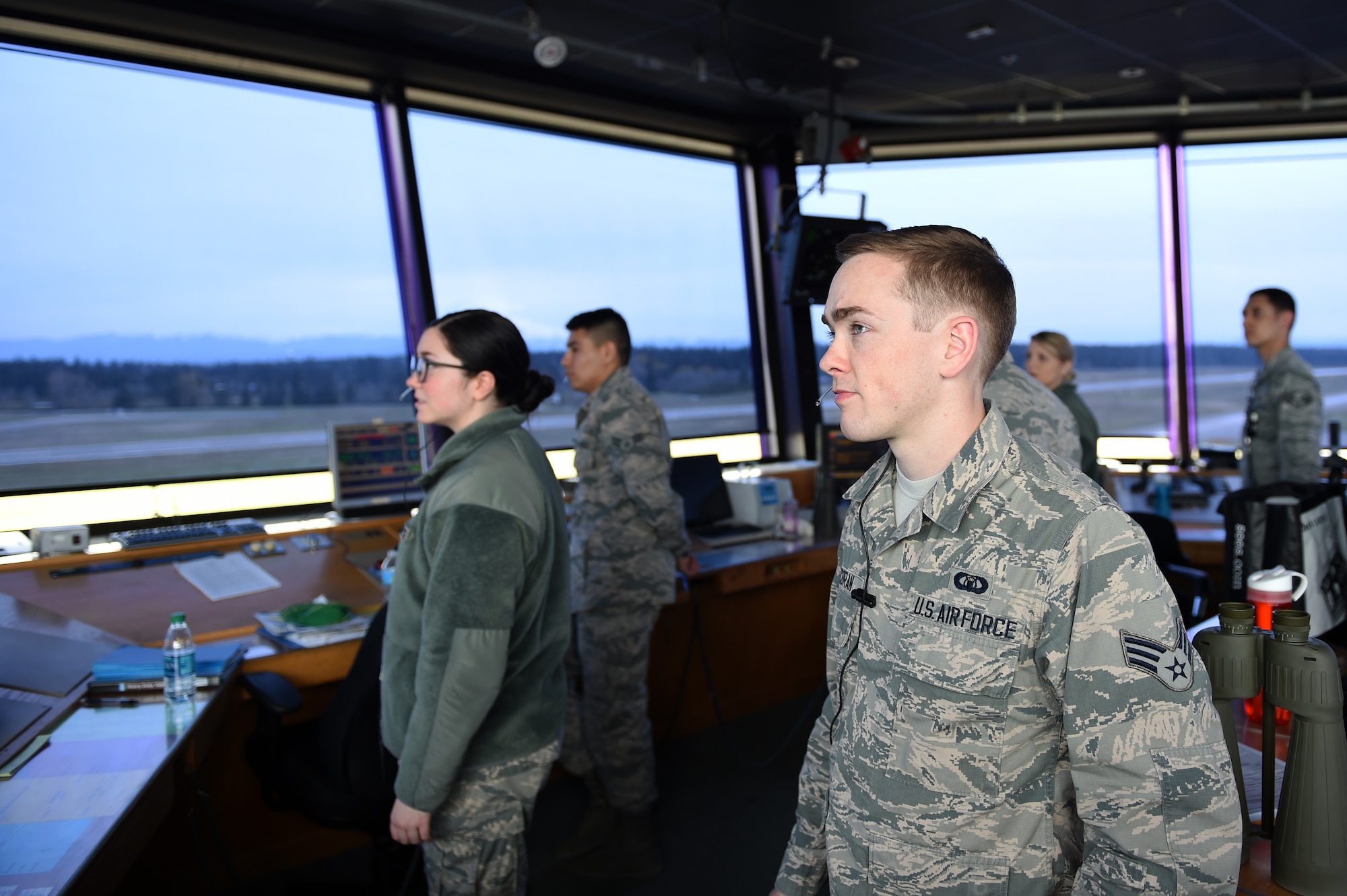 62nd Operations Support Squadron Air traffic Controllers look on at the McChord Field flight line from the tower on April 11, 2017, on Joint Base Lewis-McChord, Wash. Their job is to separate aircraft in the air and on the ground and ensure everyone’s safety all while getting the aircraft in and out as quickly as possible from the air field. (Air Force Photo/ Staff Sgt. Naomi Shipley)
