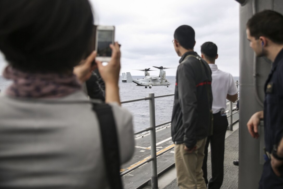 College students from Okinawa, Japan watch a Marine MV-22B Osprey land aboard the USS Bonhomme Richard (LHD 6) in the Pacific Ocean, March 25, 2017. College students from Okinawa International University, Ryukyu University and Toyo Medical Community College toured the USS Bonhomme Richard (LHD 6) as part of a military exchange experience during the 31st Marine Expeditionary Unit’s 17.1 Spring Patrol of the Indo-Asia-Pacific region. Education programs, such as this military exchange experience, increase cooperation, trust and understanding between the U.S. military and the Okinawan community. As the Marine Corps’ only continuously forward deployed unit, the 31st Marine Expeditionary Unit’s air-ground-logistics team provides a flexible force, ready to perform a wide range of military operations, from limited combat to humanitarian assistance operations, throughout the Asia-Pacific region. (U.S. Marine Corps photo by Sgt. Tiffany Edwards/Released) 