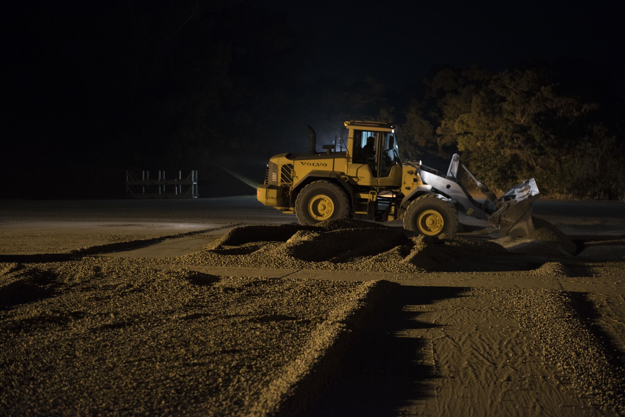 U.S. Air Force 18th Civil Engineer Squadron Airmen operate heavy machinery through the night and into the early morning during an airfield damage repair scenario of a no-notice exercise April 12, 2017, at Kadena Air Base, Japan. In of the event of an attack, the 18th CES can work around the clock to quickly restore a damaged runway, and ensure the 18th Wing is able to safely generate aircraft on a repaired runway. (U.S. Air Force photo by Senior Airman Omari Bernard)