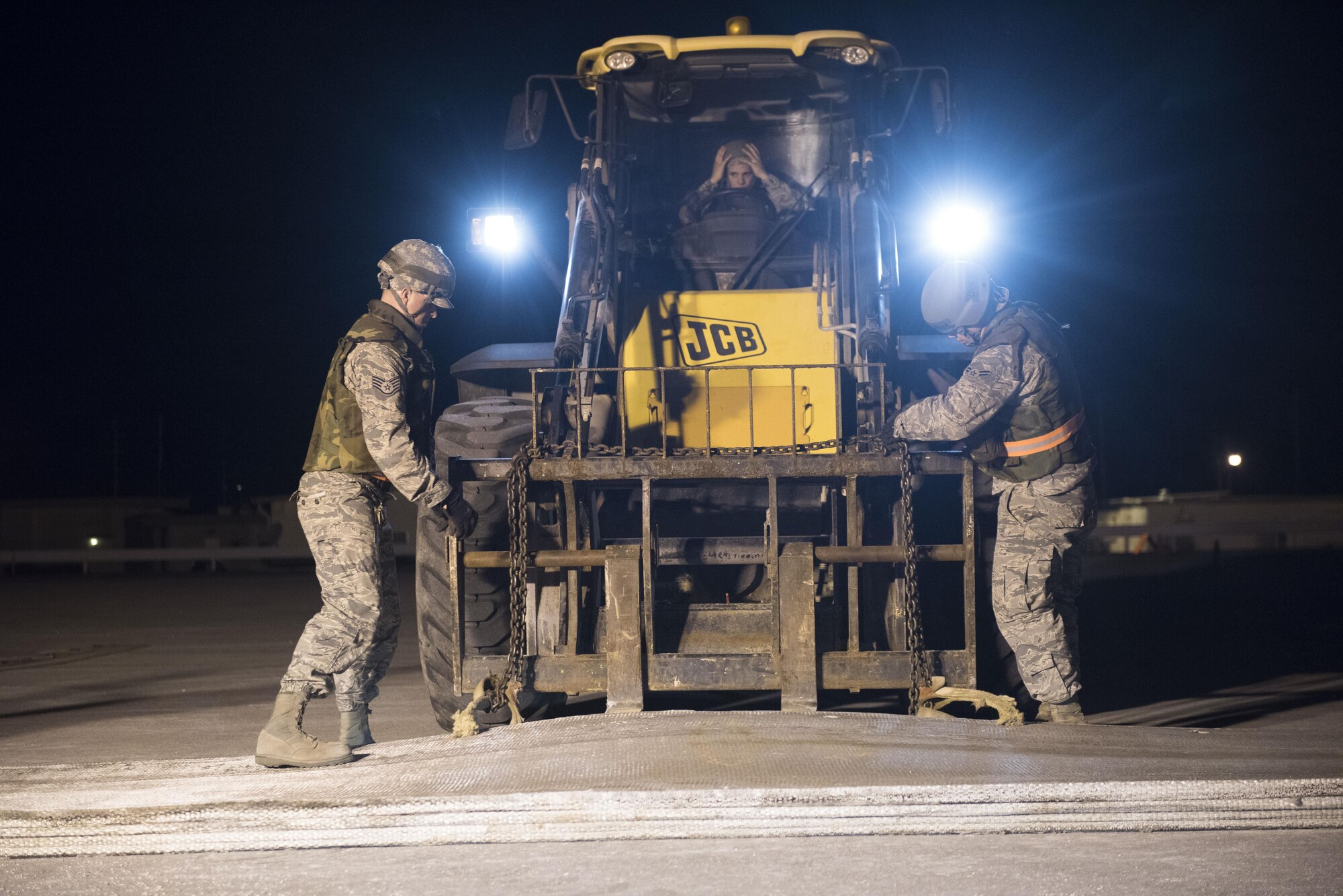 U.S. Air Force Airmen from the 18th Civil Engineer Squadron chain a fiberglass mat to a forklift during the airfield damage repair portion of a no-notice exercise April 12, 2017, at Kadena Air Base, Japan. During the exercise the 18th CES demonstrated their capability to repair a damaged runway at night to ensure continuous combat aircraft generation by the 18th Wing. (U.S. Air Force photo by Senior Airman Omari Bernard)