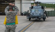 A U.S. Air Force 33rd Aircraft Maintenance Unit Airman signals to the pilot of an HH-60 Pave Hawk outside the 33rd Rescue Squadron maintenance hangar during a training sortie April 11, 2017, at Kadena Air Base, Japan. The dedicated members of Team Kadena work around the clock to provide constant operational support of mission directives in the Pacific theater for joint and allied partners to enhance peace and stability in the region. (U.S. Air Force photo by Senior Airman John Linzmeier)