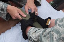 U.S. Air Force Airmen secure straps onto a litter patient during a training exercise April 12, 2017, at Kadena Air Base, Japan. In times of crisis, Airmen of the 18th Wing are expected to perform their missions with speed and accuracy. The exercise sharpened Team Kadena's capability to respond to scenarios such as a mass casualty crisis. (U.S. Air Force photo by Senior Airman John Linzmeier)