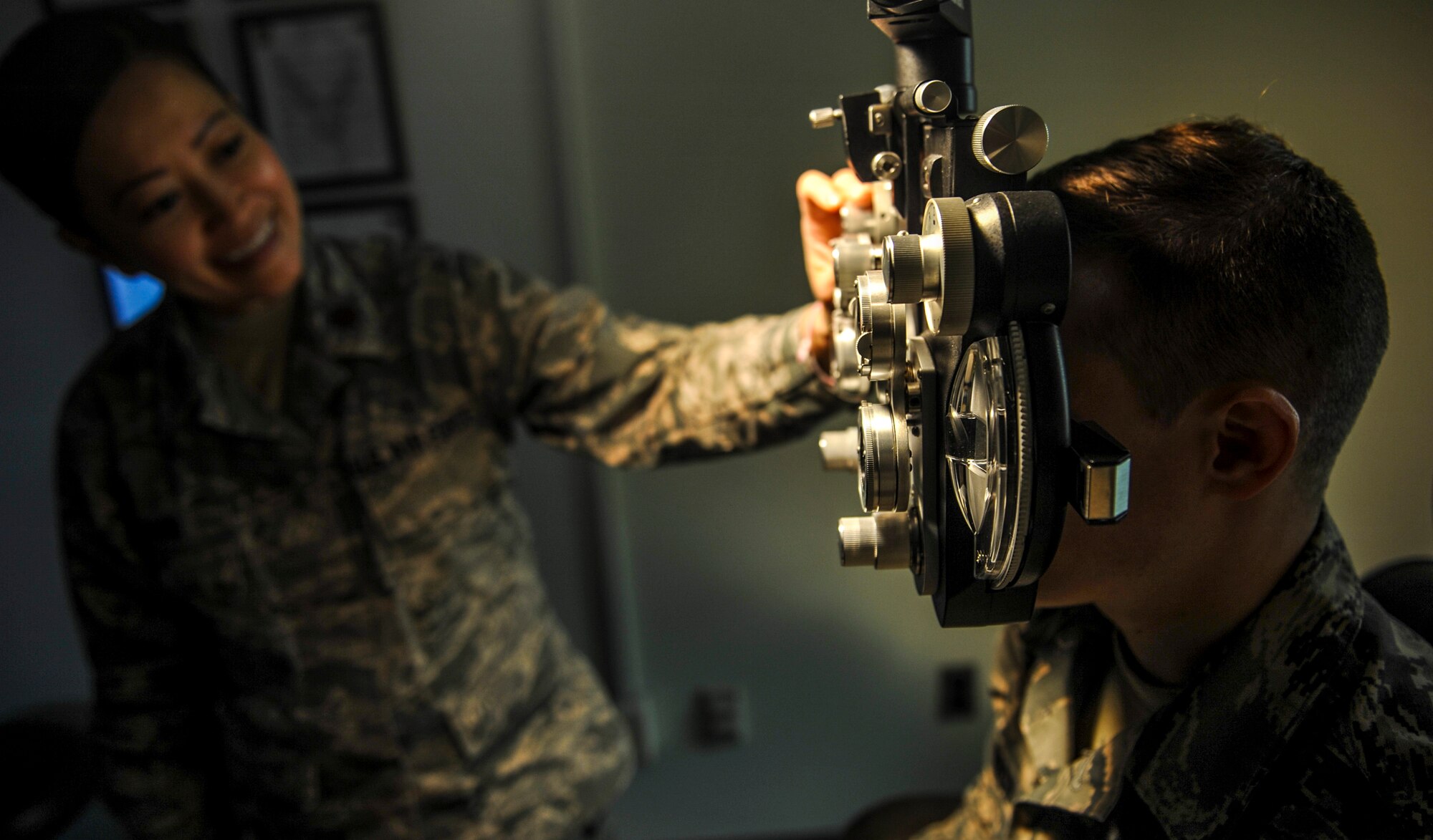 U.S. Air Force Maj. See Vang, 51st Aerospace Medicine optometry flight commander, left, changes lenses on the phoropter while Staff Sgt. River Carson, 8th Medical Operations Squadron public health technician, stares at a letter chart on at Kunsan Air Base, Republic of Korea, March 24, 2017. The phoropter checks for refractive errors in the eyes and assists in eye glass prescriptions.  (U.S. Air Force photo by Senior Airman Colville McFee/Released)