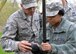 U.S. Air Force Staff Sgt. Miguel Montiel, left, 100th Civil Engineer Squadron Engineering Execution Support journeyman, instructs an Airman from the 48th Civil Engineer Squadron on how to correctly use the survey equipment to plot coordinates of marked items during an aircraft crash response/search and recovery training April 7, 2017, on RAF Lakenheath, England. Items simulating aircraft parts and human remains were scattered around the duck pond on base as Airmen from RAF Mildenhall, RAF Lakenheath and 927th Force Support Squadron Reserves, MacDill Air Force Base, Fla., participated in the training. (U.S. Air Force photo by Karen Abeyasekere)