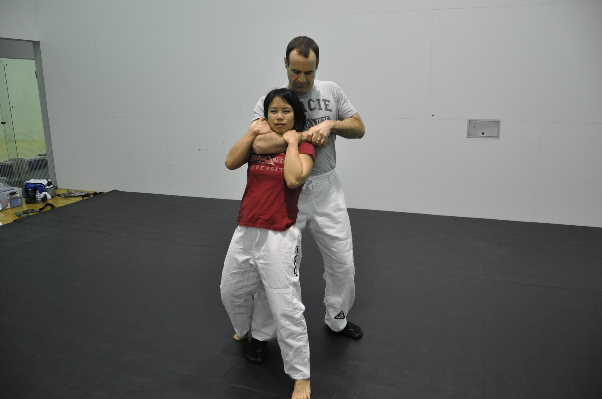 Caroline King (front) an electronics engineer in the Air Force Research Laboratory’s Aerospace Systems Directorate, a Gracie Defense instructor, demonstrates how to get out of a rear choke. Eric Treadwell simulates the role of attacker. (U.S Air Force photo / Brian Brackens)