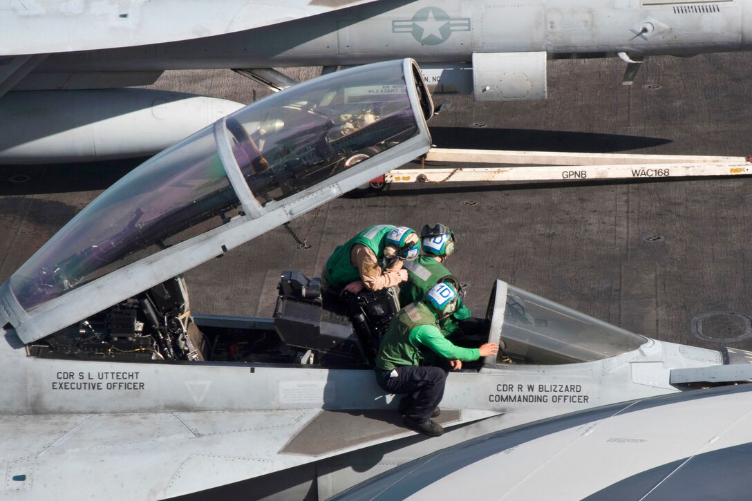 Sailors inspect the cockpit of an F/A-18F Super Hornet aircraft on the flight deck of the aircraft carrier USS Dwight D. Eisenhower in the Atlantic Ocean, April 2, 2017. Navy photo by Seaman Neo Greene III