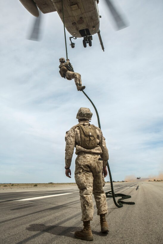 Marine Corps 2nd Lt. Anthony M. Goliver, foreground, observes Marines rappelling out of a CH-53E Super Stallion helicopter during a fast-rope exercise as part of Weapons and Tactics Instructors Course 2-17 at Auxiliary Airfield II in Yuma, Ariz., April 7, 2017. Goliver is an infantry officer assigned to Weapons Company, 2nd Battalion, 6th Marine Regiment. Marine Corps photo by Lance Corporal Clare J. Shaffer